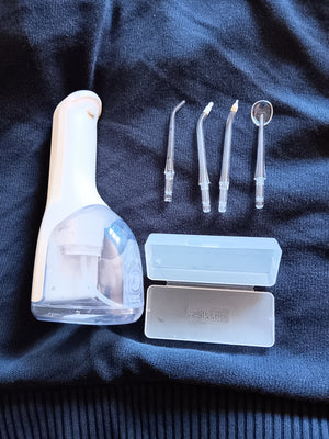 Customer photo: Hetrios Water Flosser laid out with its four nozzles and storage case